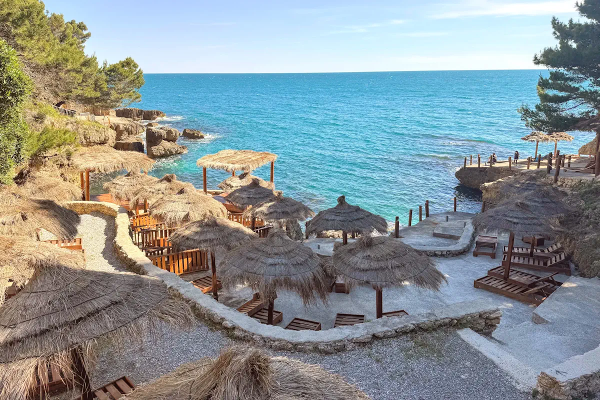 Albatros Beach concrete sunbathing decks surrounded by pine forest trees in Ulcinj