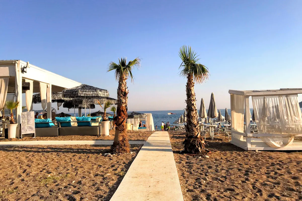Becici Beach, Beach Club with white Bali beds and palms