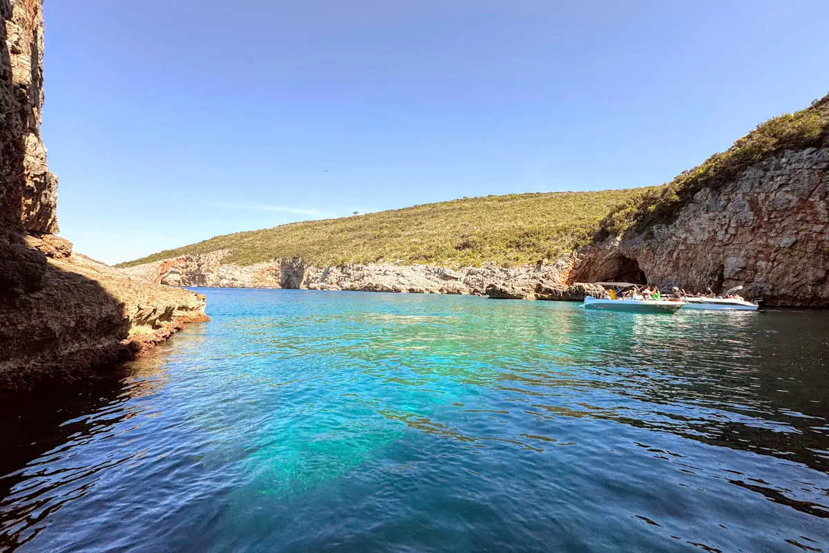 Excursion boats anchored outside the Luštica Peninsula cliffs near Blue Cave