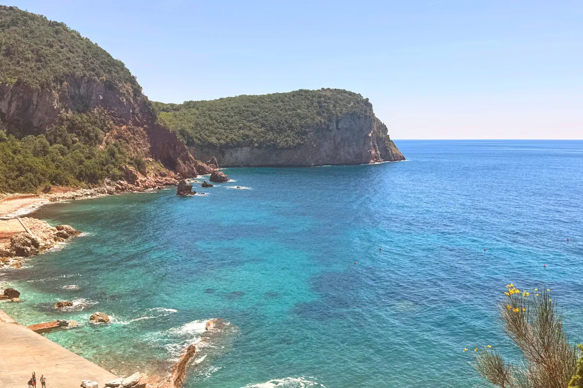 Panoramic view of Crvena Glavica cove with dramatic crimson cliffs and teal Adriatic waters