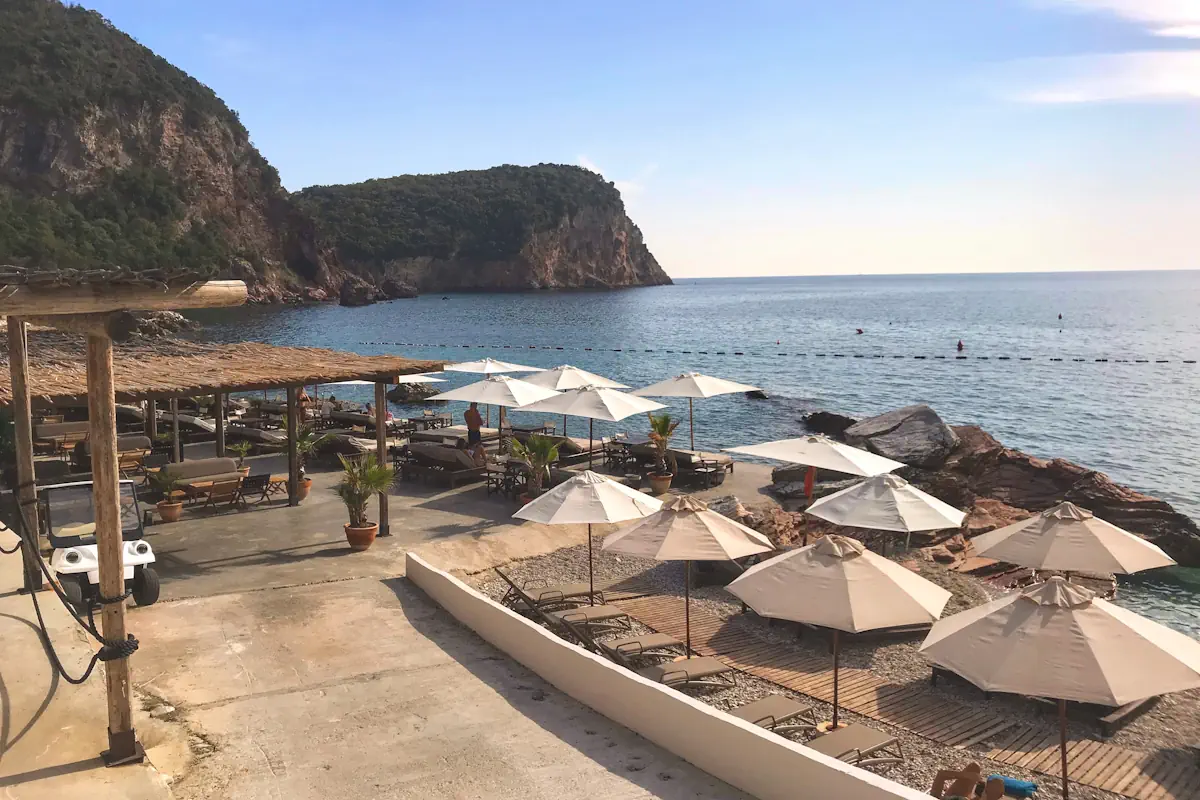 Sun loungers lined along the concrete sunbathing pier at Galija Beach Club extending into deep blue waters