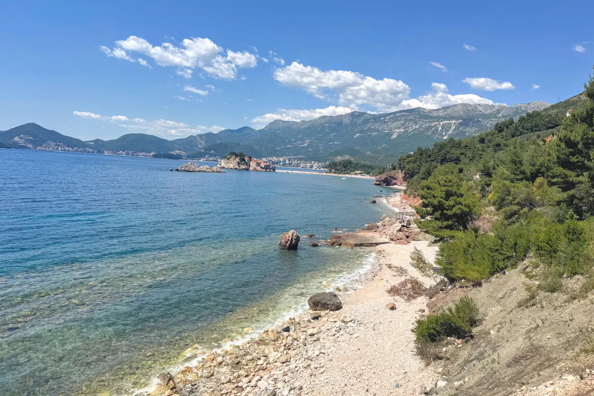 Crvena Stijena Beach near Sveti Stefan with large red rocks and crystal-clear waters