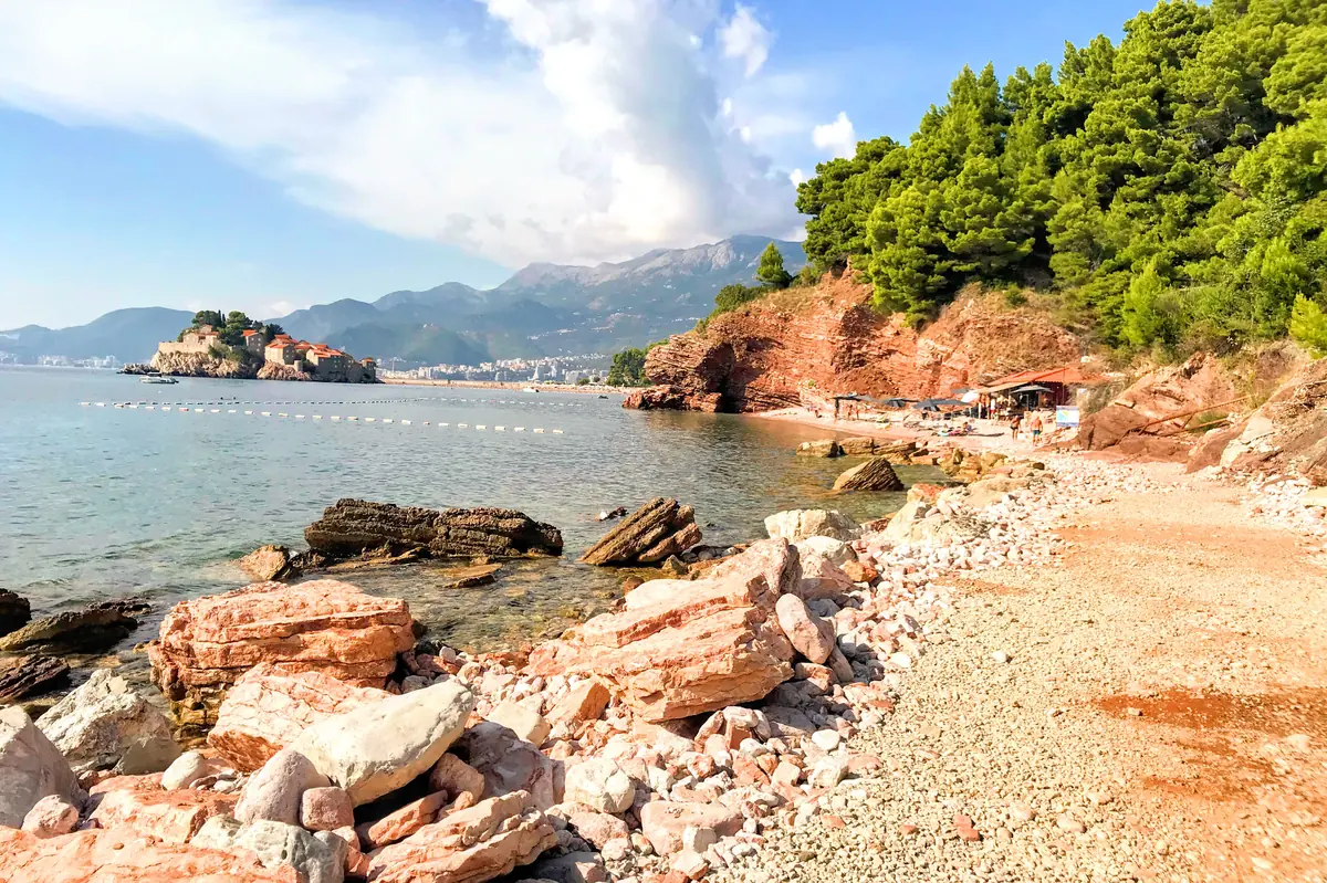 Crvena Stijena Beach near Sveti Stefan with large red rocksand crystal-clear waters