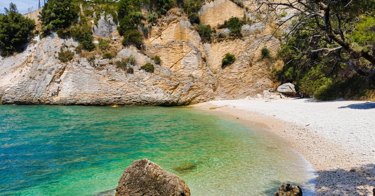 Crystal Beach with turquoise water, white pebbles, and wild vegetation