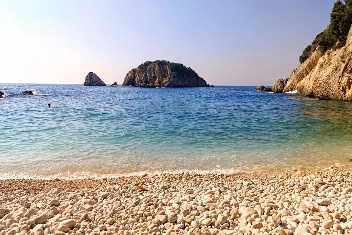 The Caribbean-blue cove of Crystal Beach Montenegro overlooking Stari Ulcinj Island