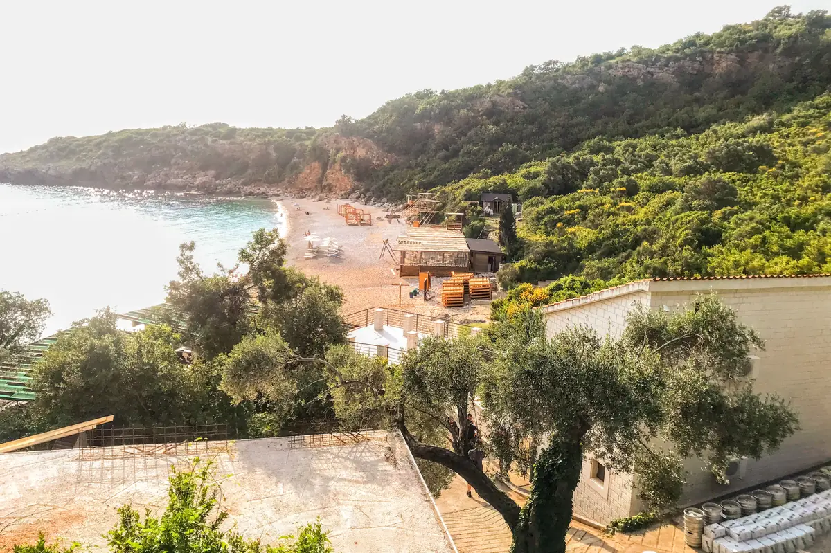 Drobni Pijesak Beach showing the turquoise water, white pebbles, on-site beach bar, and lush Mediterranean vegetation