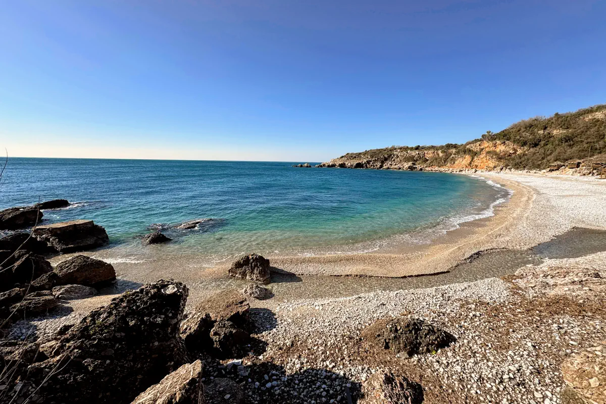 The crystal clear waters and white pebbles of Drobni Pijesak Beach near Sveti Stefan