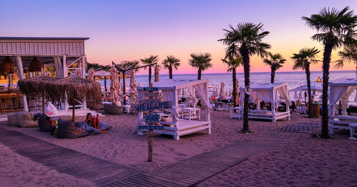 Kamenovo Beach near Budva showing its forget-me-not white cabanas, palm tres, and on-site restaurant