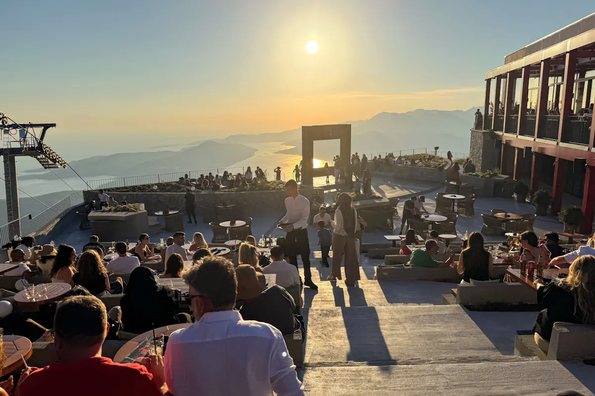 The premium outdoor dining terrace setup at Forza Kuk restaurant, framed against the Outer Bay of Kotor and Tivat's Coastal Plains