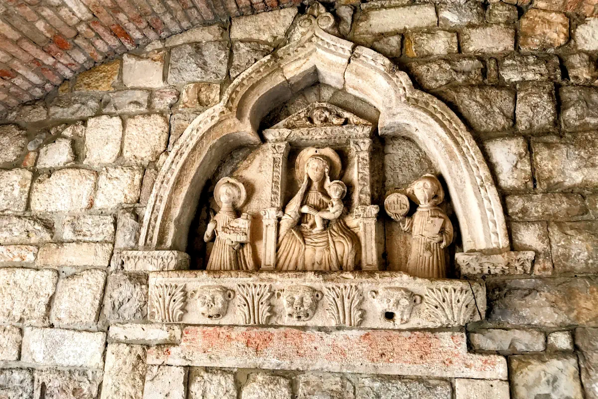 A 15th-century stone relief inside the passage of the Sea Gate in Kotor, Montenegro, depicting the Virgin Mary and saints Tryphon and Bernard
