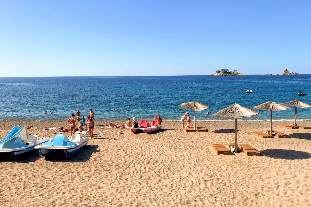 Lucice Beach central part with paddleboat rentals and children playing, Katic islet in the background