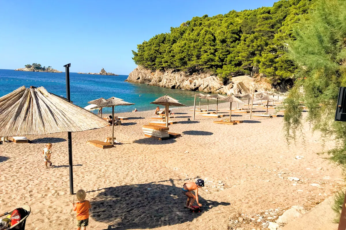 Jaz Beach northern end sun loungers and parasols with kids playing