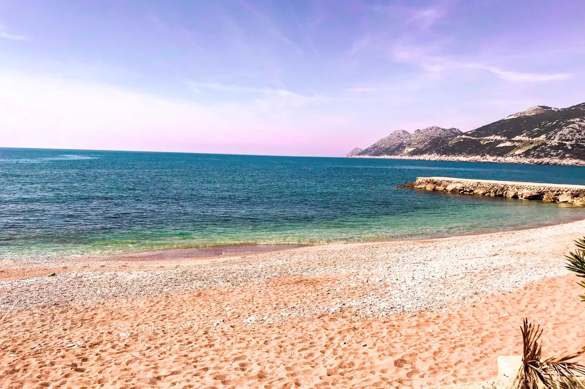 Mali Pijesak Beach in Dobra Voda with clear water and smooth pebbles overlooking the bay south of Bar