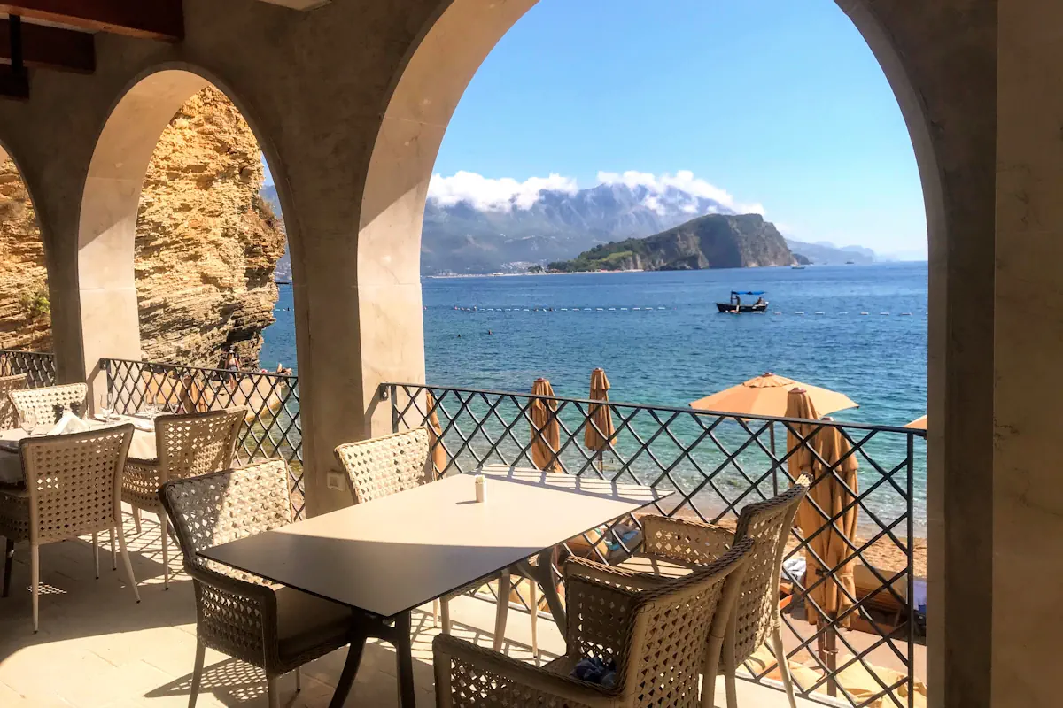 View of Sveti Nikola Island and the crystal-clear waters of Mogren Beach from the beach restaurant