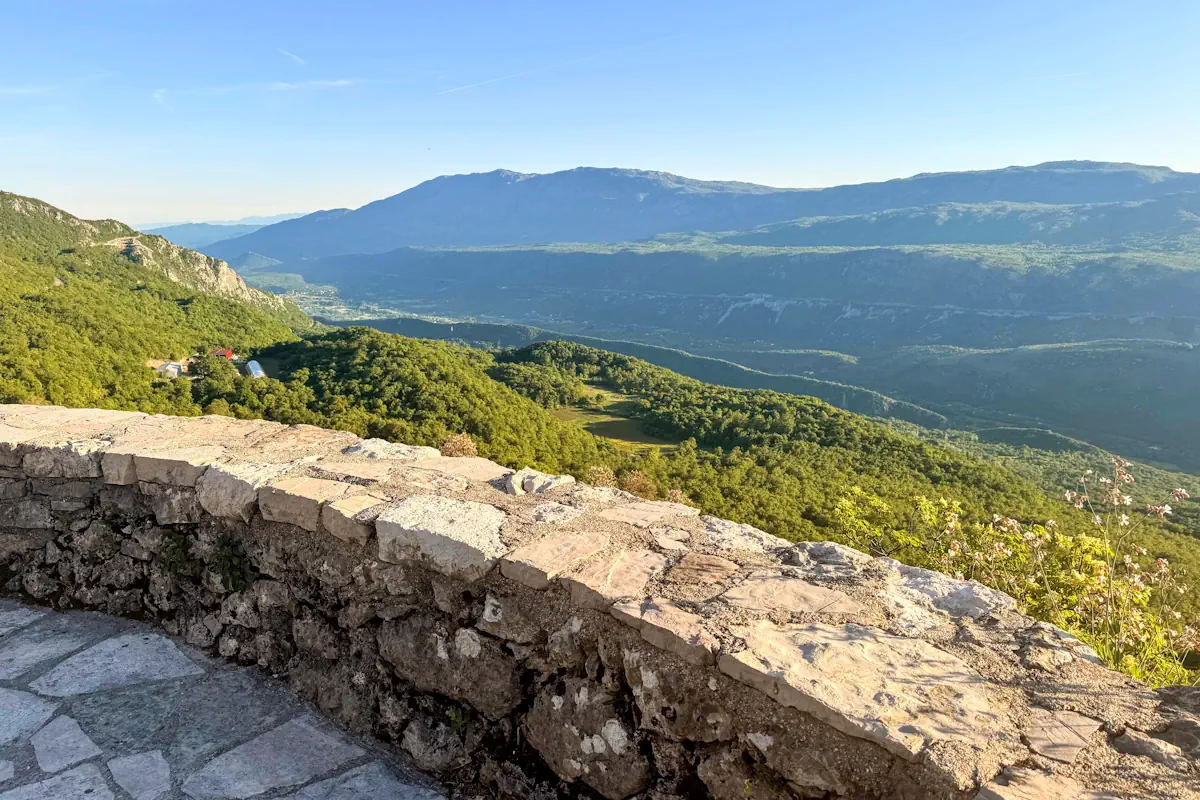 Circular stone observation deck at Ostrog Monastery with view of Zeta Valley