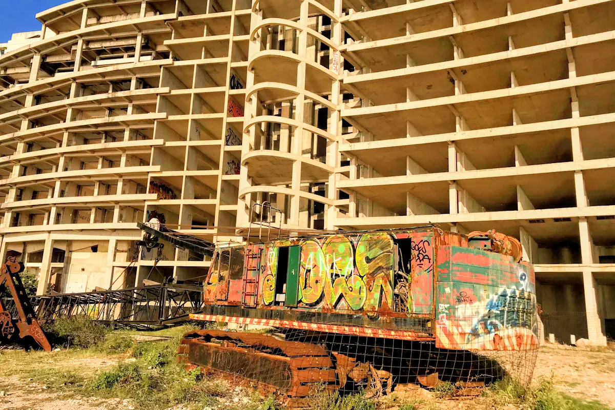 The monumental, unfinished concrete structure of Hotel AS towering over Perazica Do