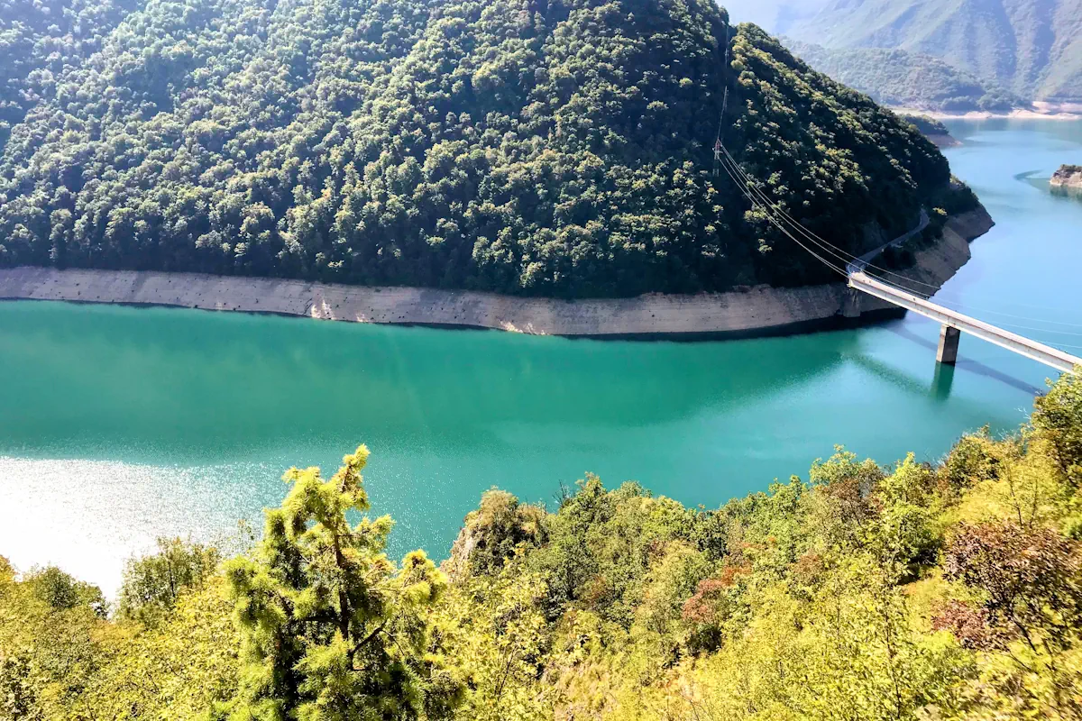 The turquoise Piva Lake snaking through the limestone canyon from above