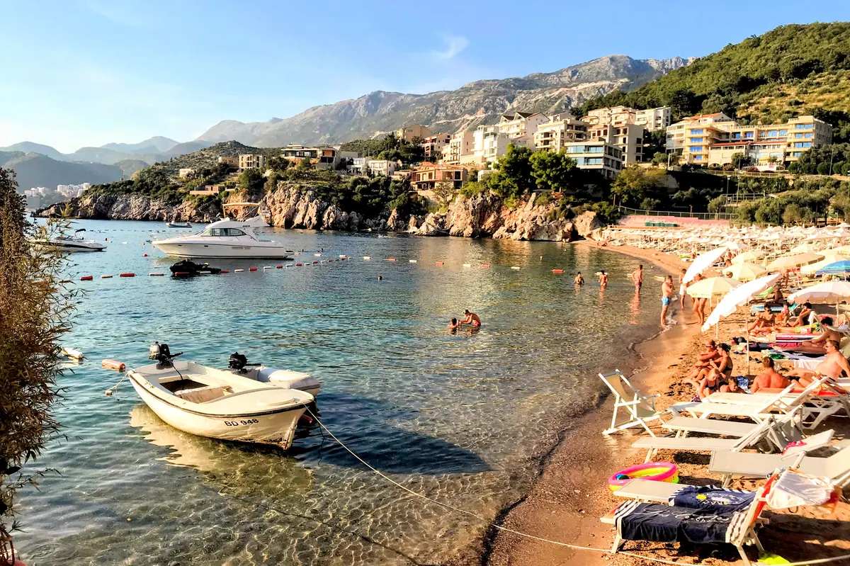 View of villa-dotted coast, crystal-clear waters, pricey sun loungers and fishing boats from Przno Beach