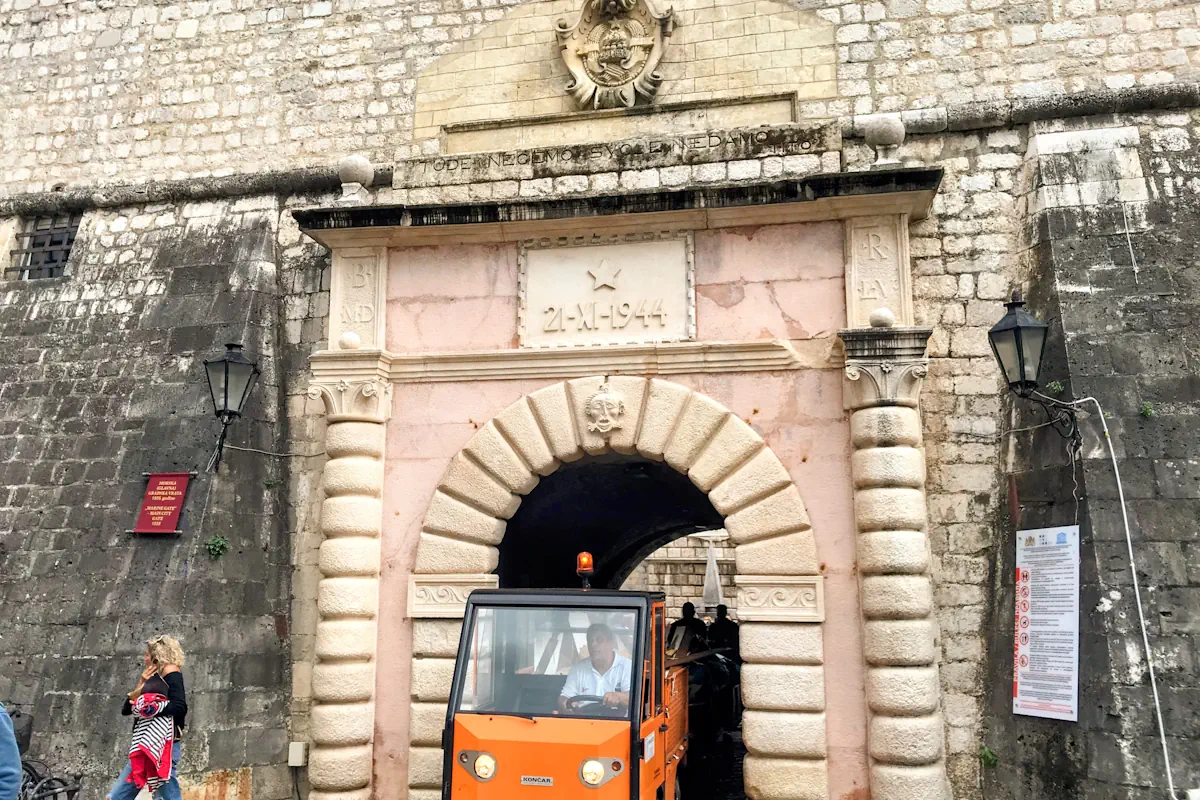 The front facade of the Sea Gate in Kotor Old Town, Montenegro, showing the transition from Venetian to Yugoslav symbolism