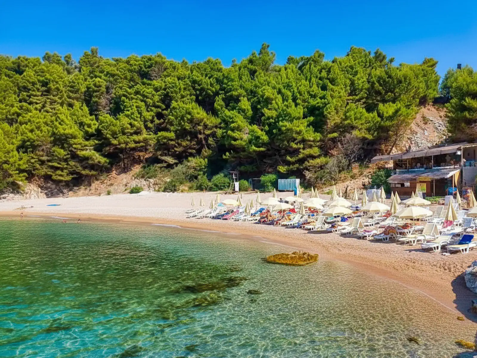 Strbina Beach southern end with sun loungers and crystal clear waters