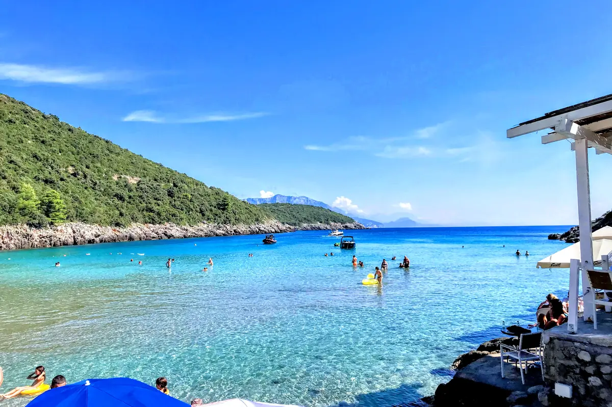Trsteno Beach near Budva, a narrow sandy cove with crystal clear shallow water and lush greenery