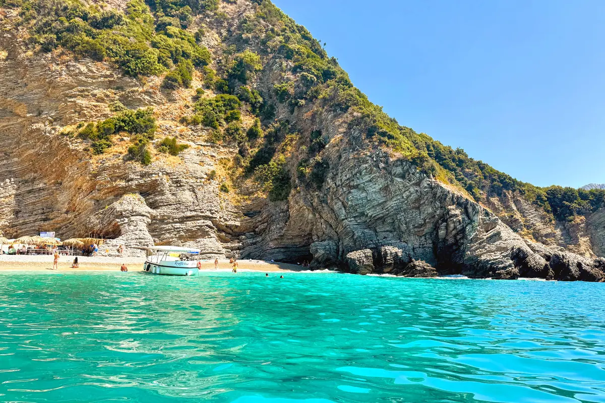 The electric turquoise waters and towering limestone cliffs of Vezir's Beach Montenegro