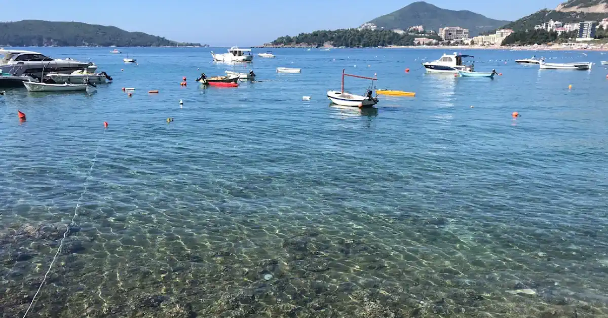 Wide view of the crystal clear waters and long pebble shoreline and luxury hotels at Bečići Beach, picture taken from Rafailovici, Budva Riviera