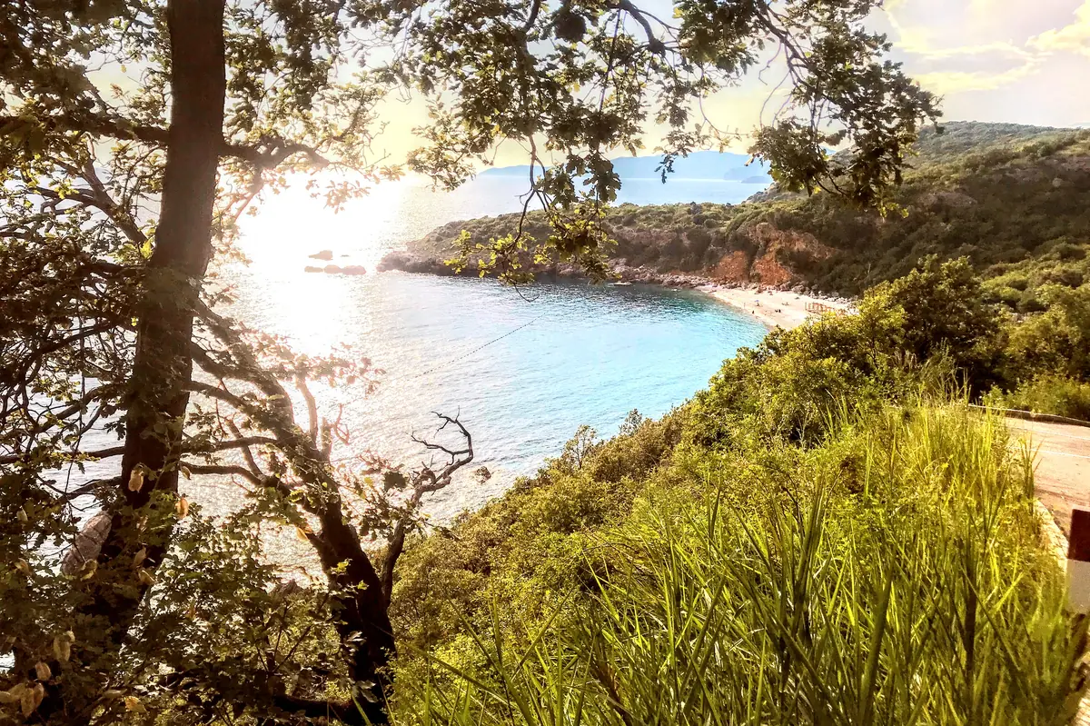 Azure waters and white pebbles at Drobni Pijesak beach near Sveti Stefan, Montenegro