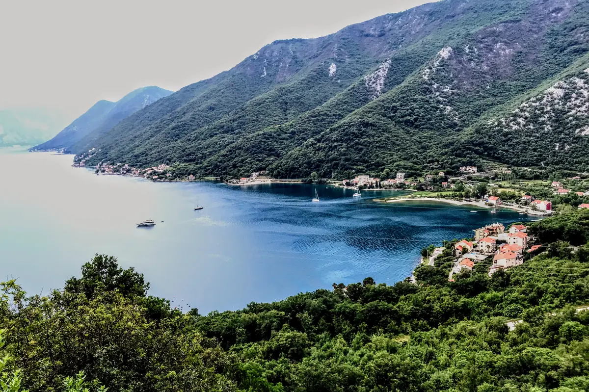 Aerial view of the tranquil Morinj beach with lush greenery and mountains in Kotor Bay