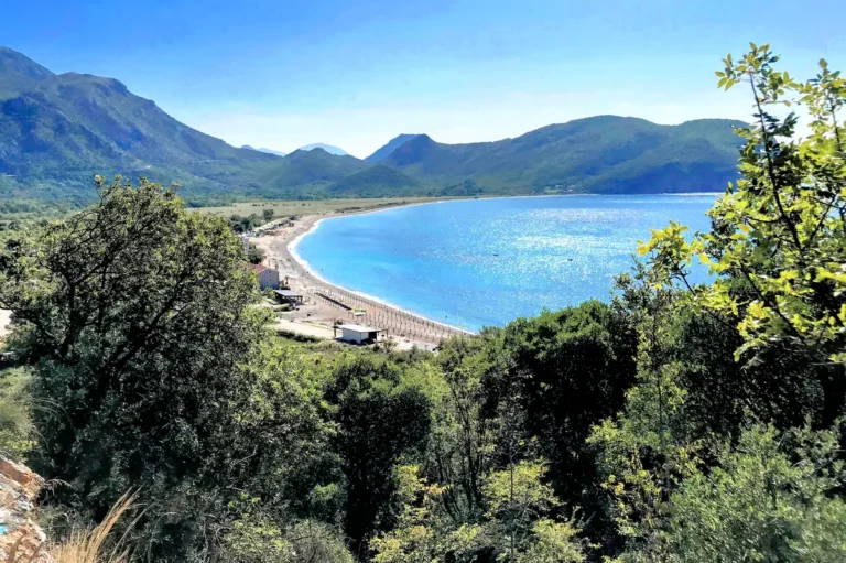 Panoramic view of the long pebble shoreline of Buljarica Beach seen from the coastal hiking trail connecting to Lučice, Montenegro