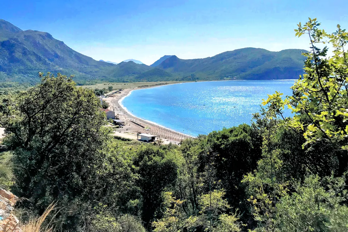 Panoramic view of the long pebble shoreline of Buljarica Beach seen from the coastal hiking trail connecting to Lučice, Montenegro