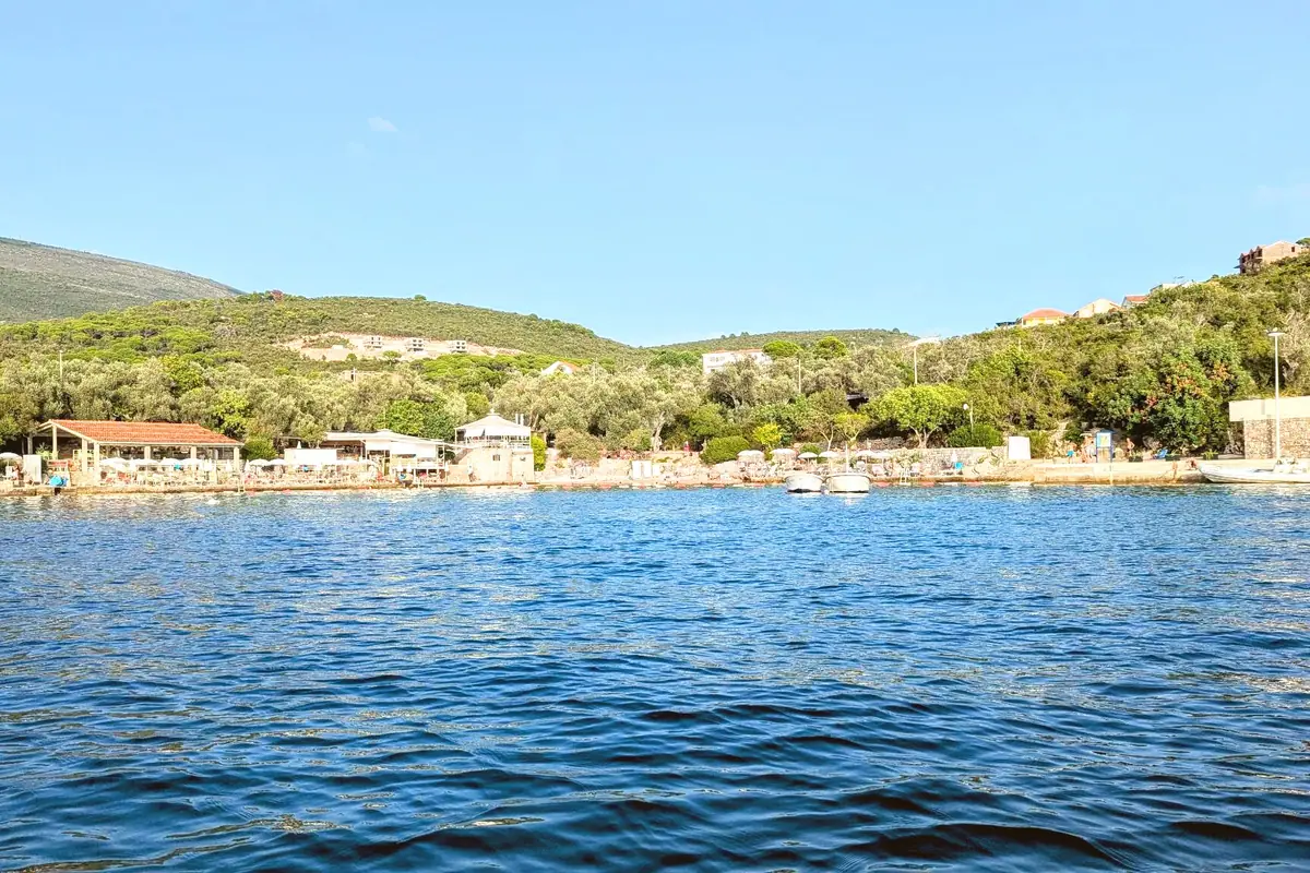 The olive tree fringed cove of Miriste Beach on the Lustica Peninsula photgraphed from a boat