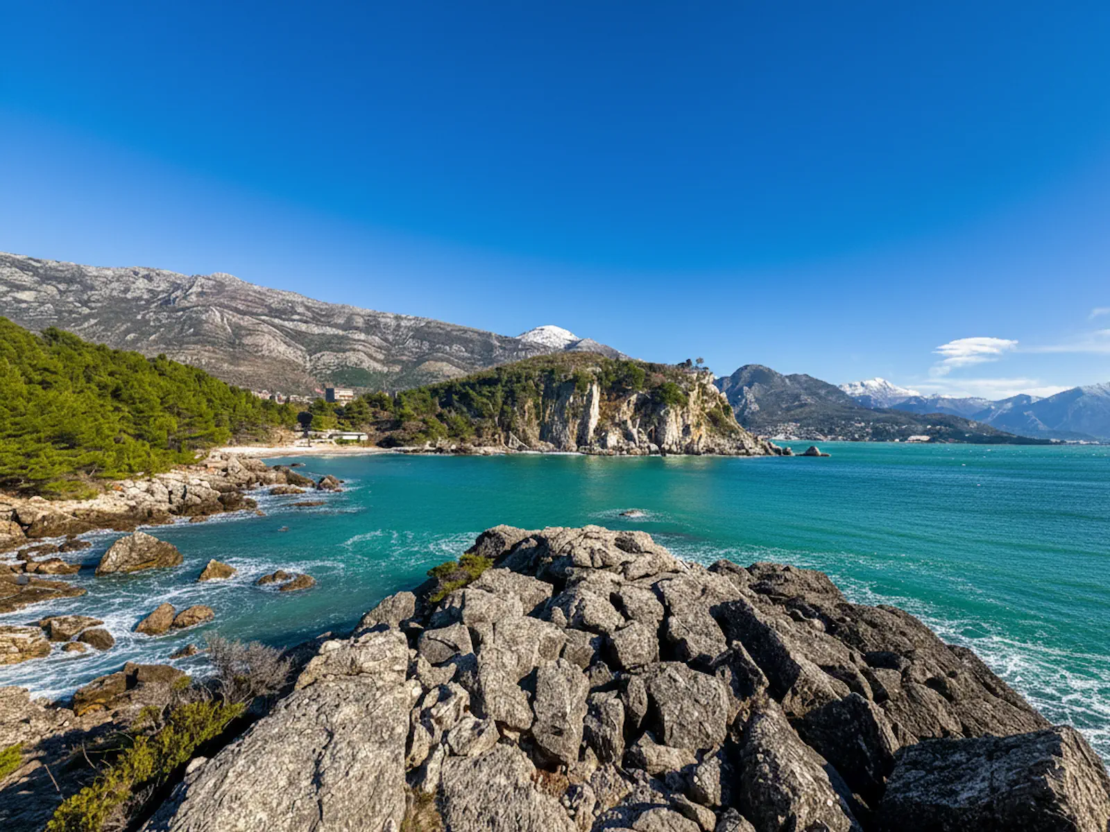 Strbina Beach near Sutomore, surrounded by pine trees, scenic cliffs, and turquoise waters of the Adriatic