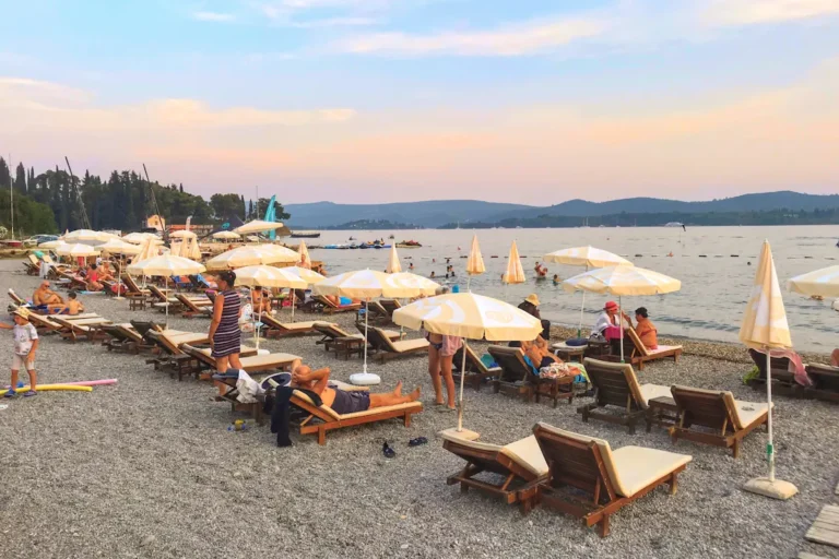 Three rows of sun loungers and parasols at Belane Beach in Tivat Montenegro
