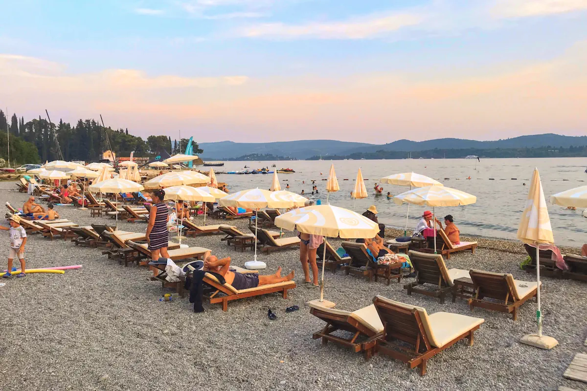 Three rows of sun loungers and parasols at Belane Beach in Tivat Montenegro