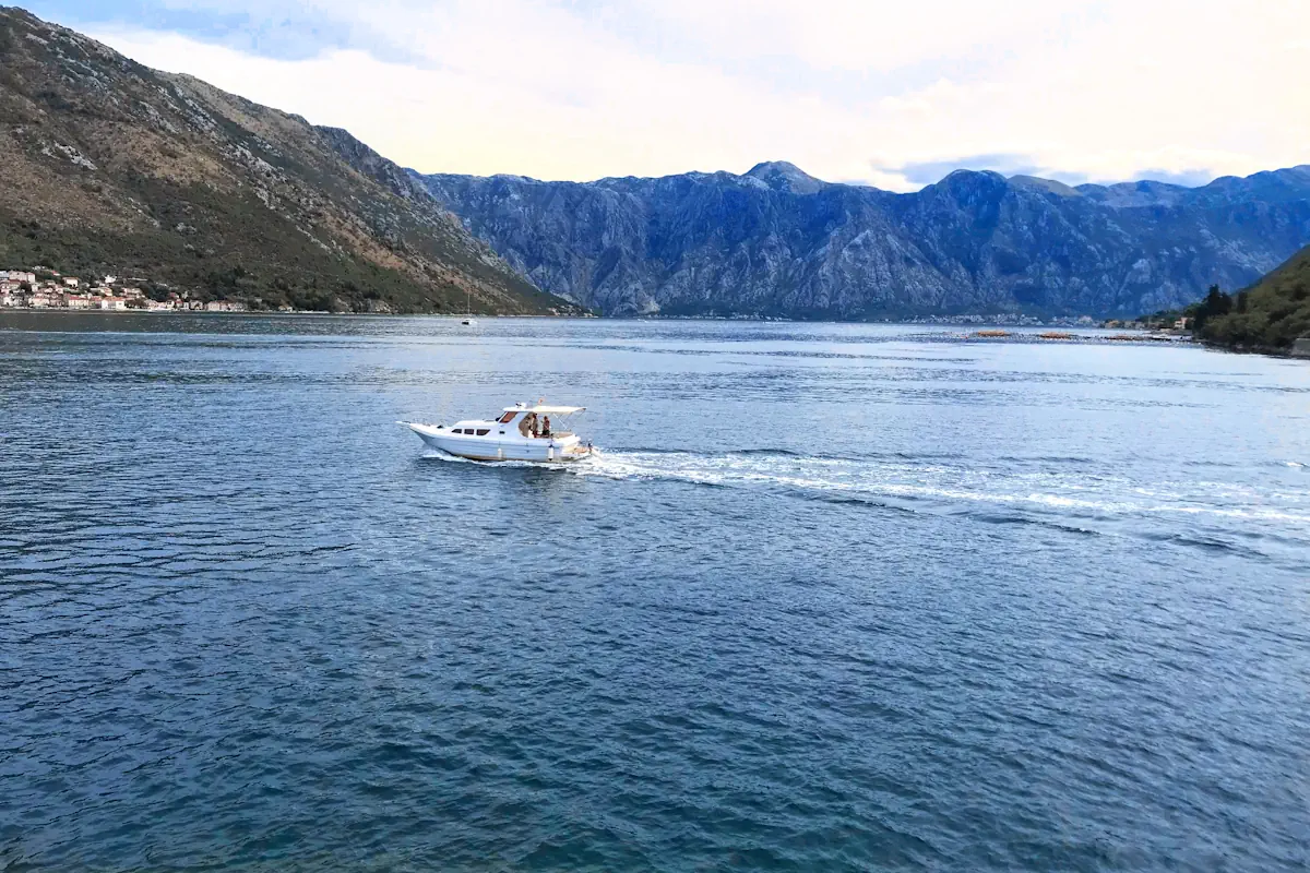 Scenic view of a boat passing through the Verige Strait in the Bay of Kotor, taken from the bus route between Herceg Novi and Kotor.