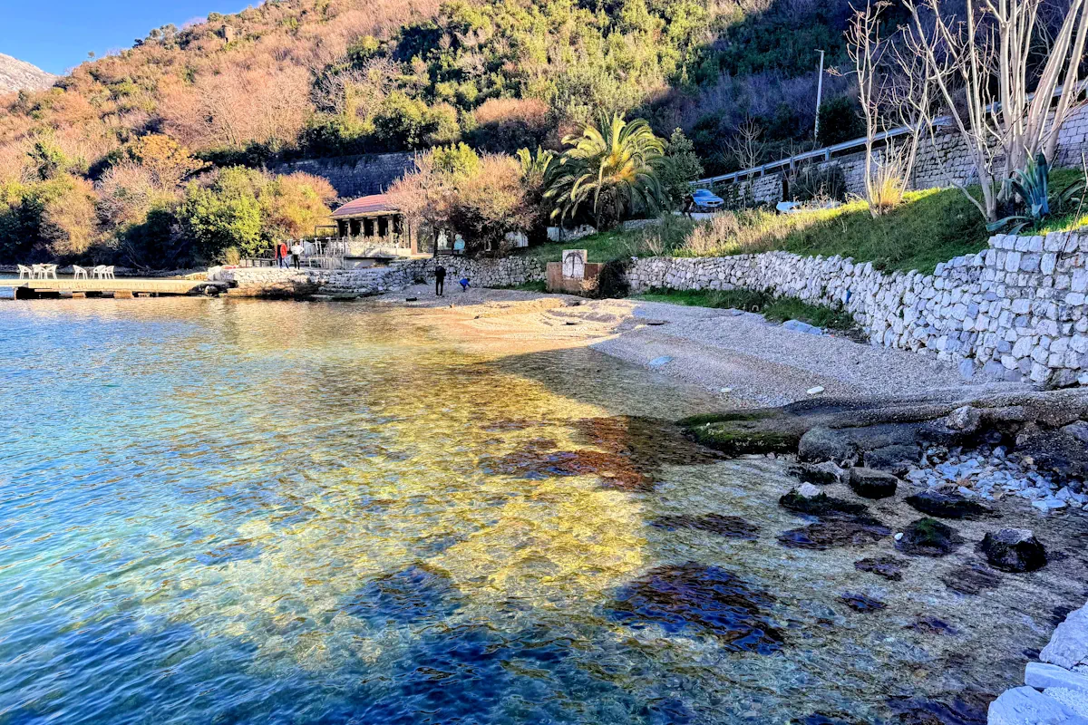 Crystal Clear bay waters at Verige Pebble Beach and pontoon in Kamenari north of Tivat, Montenegro