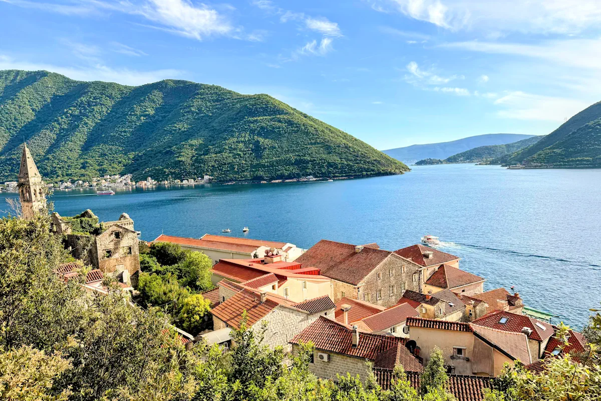 Aerial View of Perast, its red, Mediterranean roof tiles, and the Verige Strait from the upper coastal road
